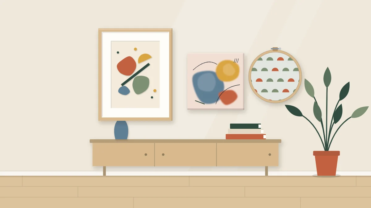 Living room wall above a low console with a framed paper collage, a small abstract canvas and a round fabric hoop
