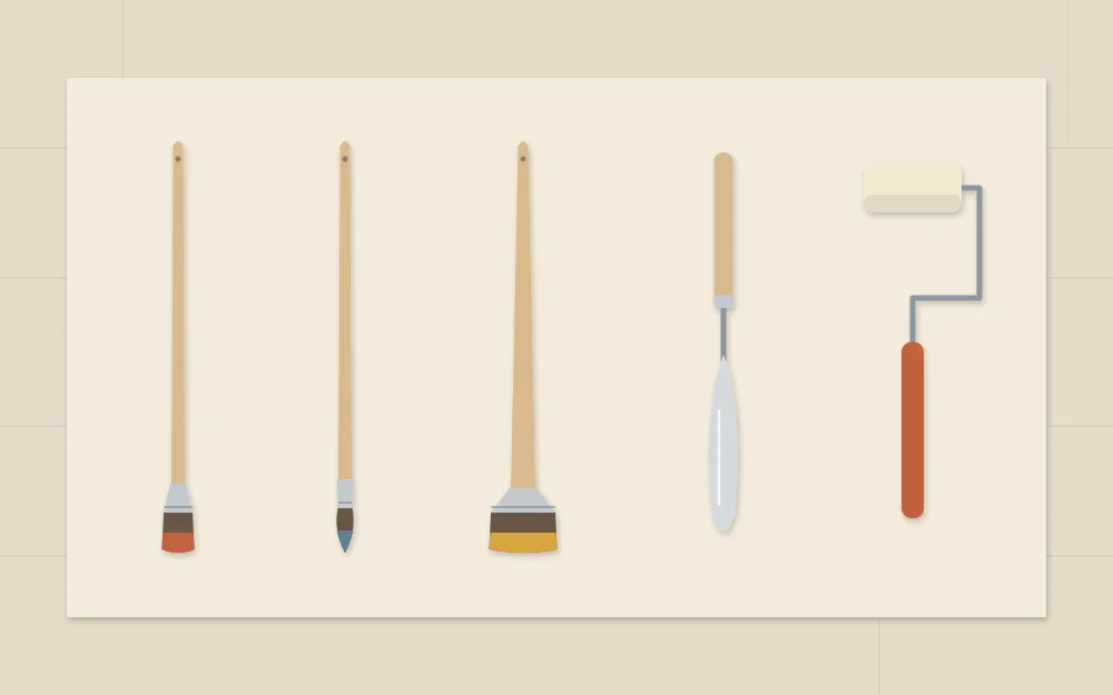 Flat, round and wide brushes laid in a row beside a palette knife and a small foam roller