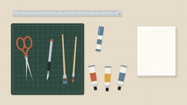 Flat lay of scissors, a craft knife, a metal ruler, a glue stick, three paint tubes, two brushes and a small blank canvas