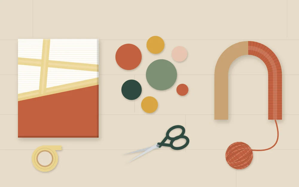 Work table with a taped canvas, cut paper circles and a cardboard shape half wrapped in yarn