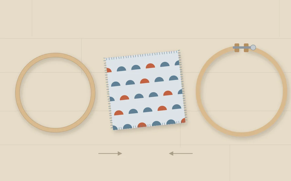 An embroidery hoop separated into inner and outer rings with a fabric square between them