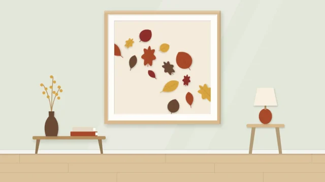 A framed artwork with paper leaves in rust, ochre, deep red and brown drifting diagonally across a cream background