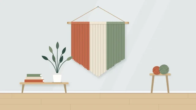 A yarn wall hanging on a wooden dowel with dense strands in three color bands trimmed to a V shape