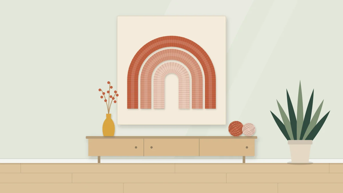 Three nested yarn-wrapped arches in graduated colors mounted on a pale board on a wall